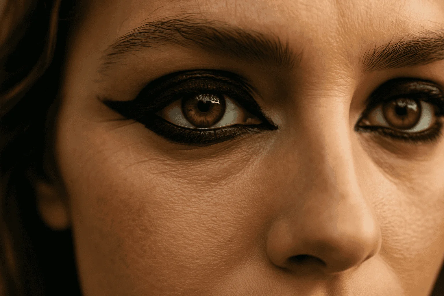 A close up of a woman's eyes. Kohl is used to heavily line the rims of her eyes.