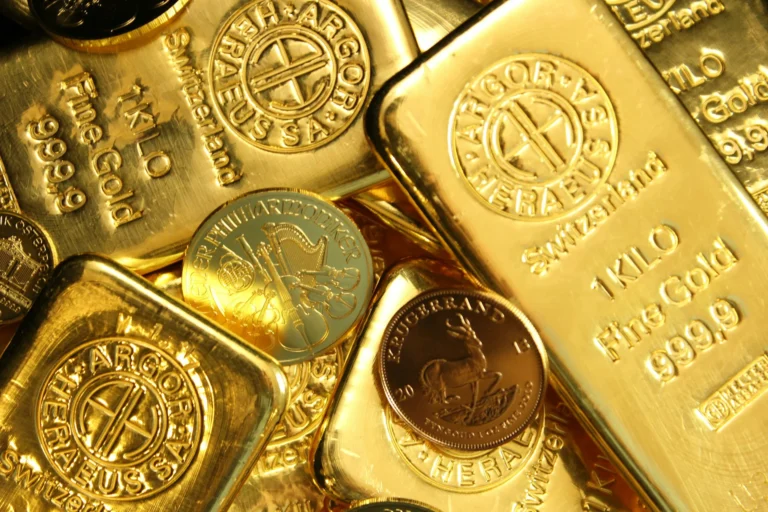 Gold bars and coins are stacked in a pile