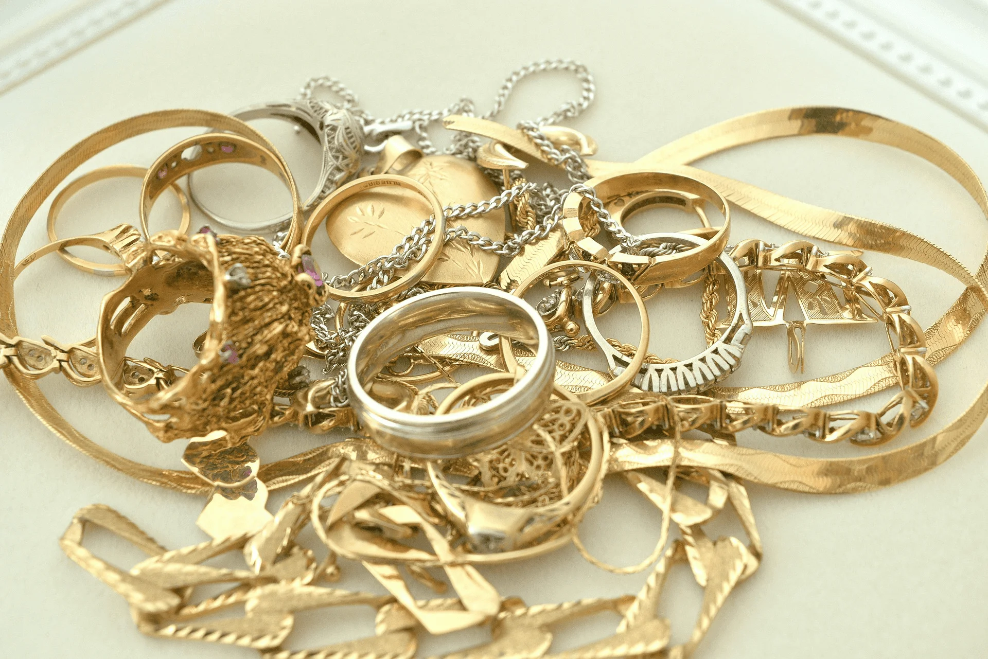 Scrap gold jewelry is piled up on a tabletop
