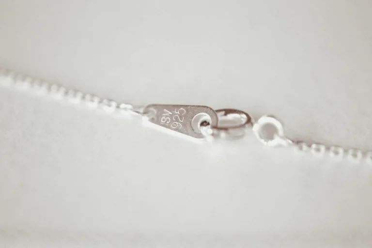 A silver necklace clasped closed with a 925 stamp on it