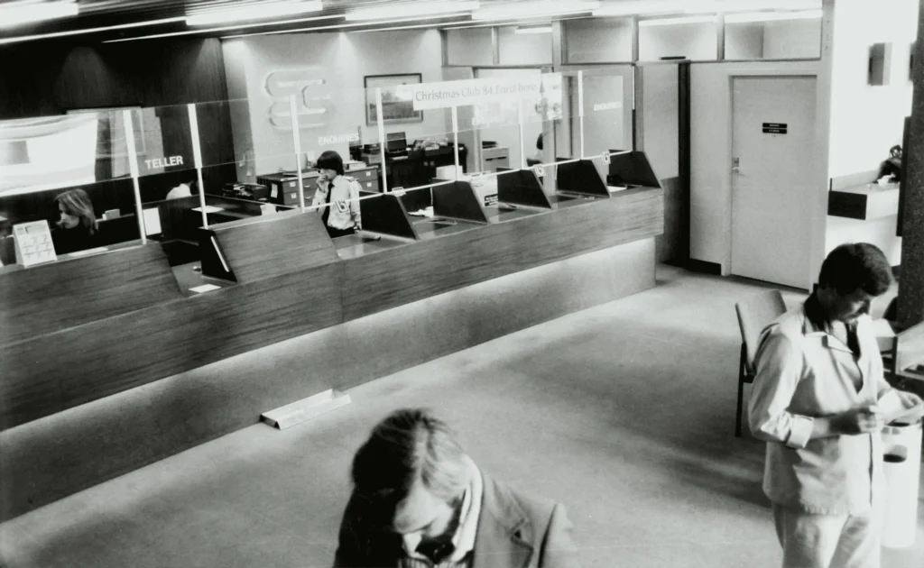 The lobby of a bank with tellers behind plexiglass