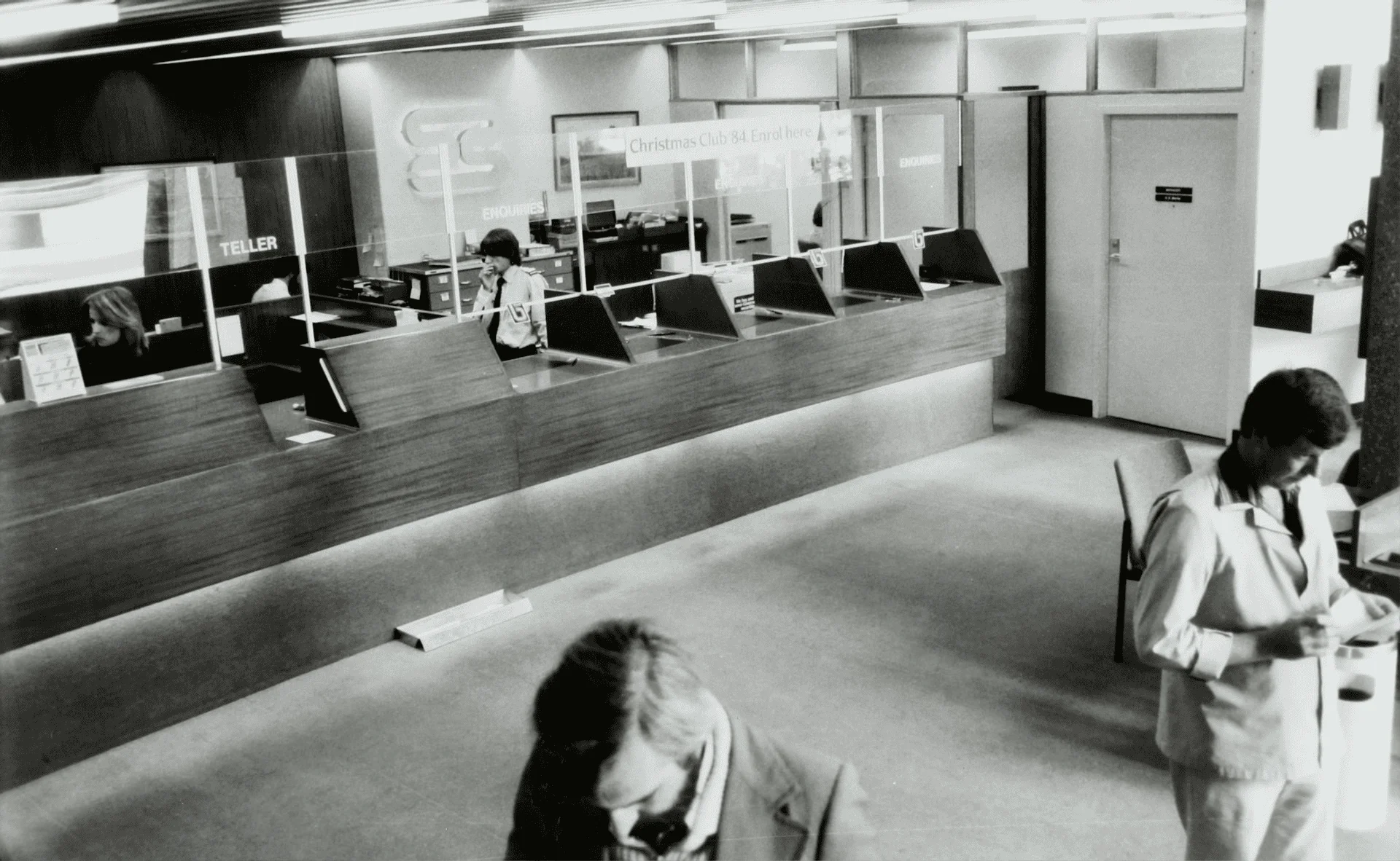 The lobby of a bank with tellers behind plexiglass