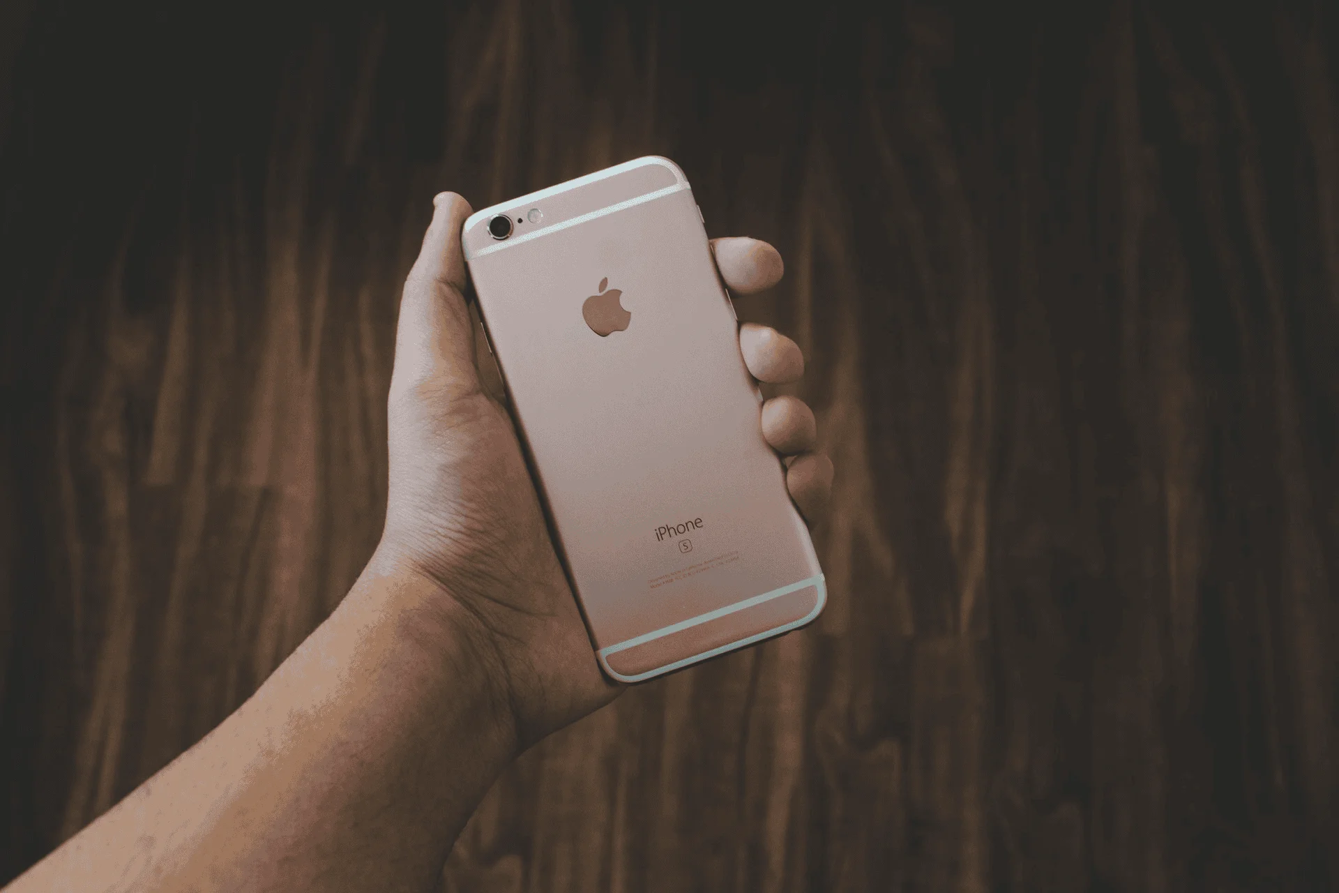 Man holding a rose gold Apple iPhone