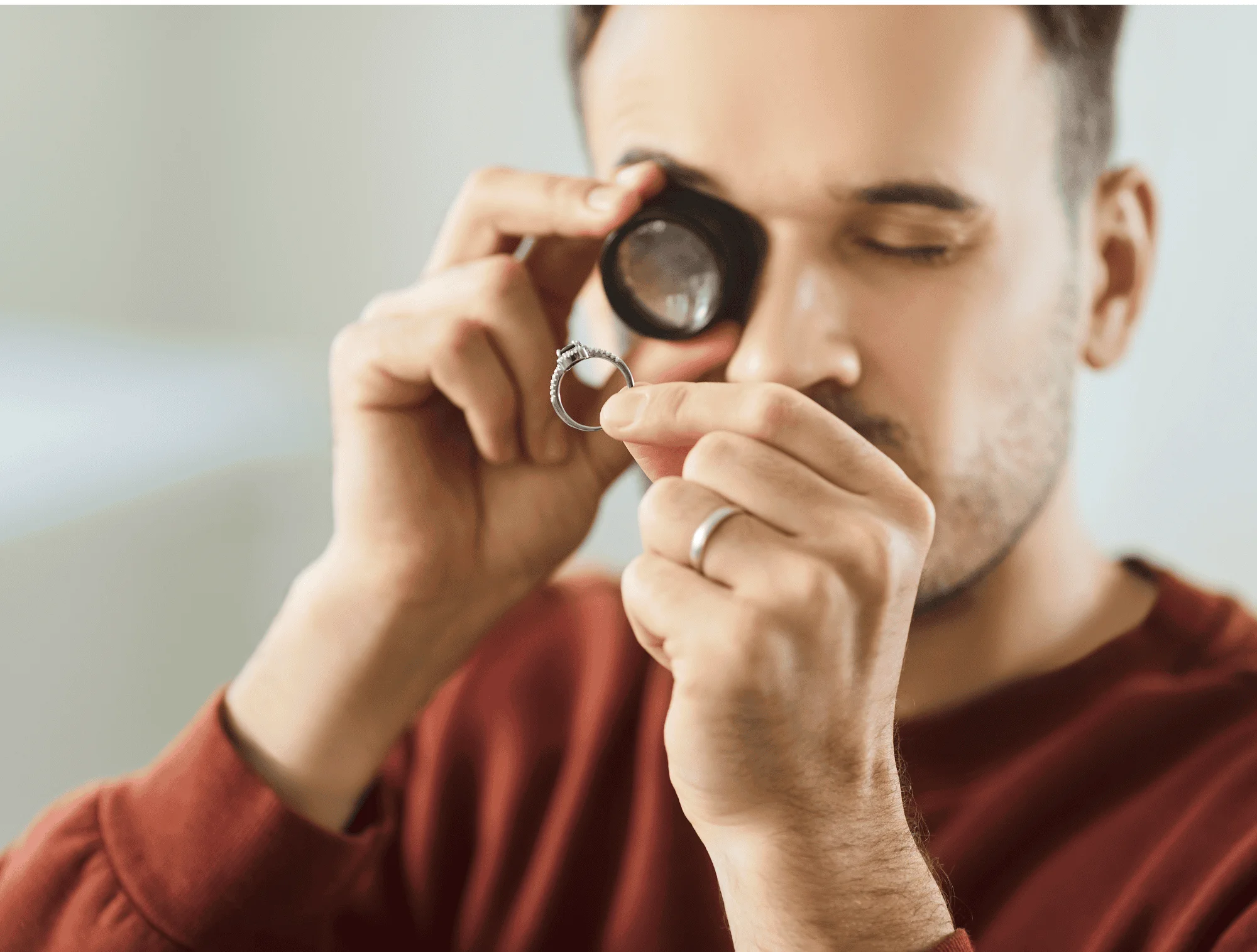 a man inspects jewelry for hallmarks