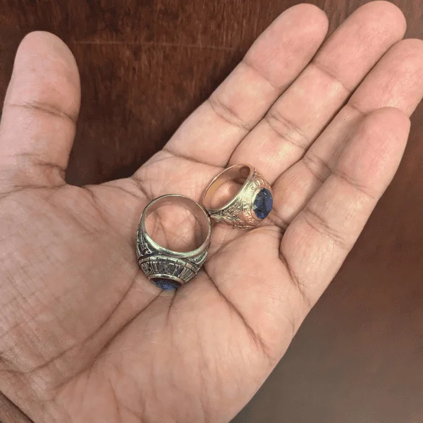 two class rings in an open palm