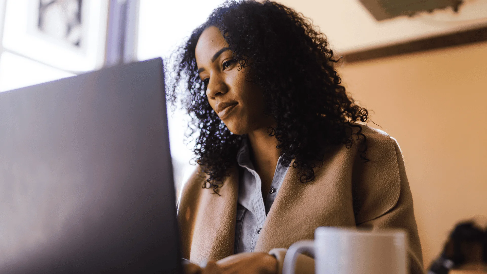 A woman sits at her computer
