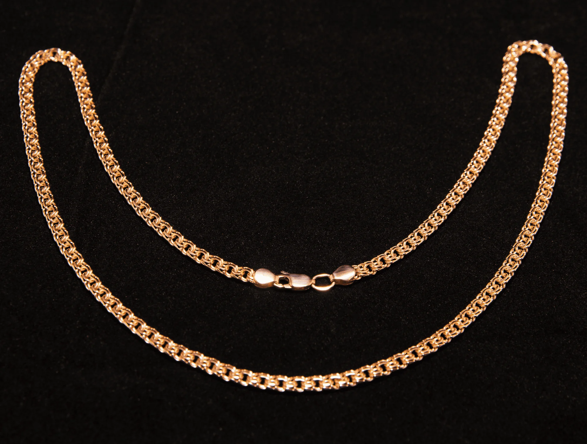 a gold chain on a black backdrop