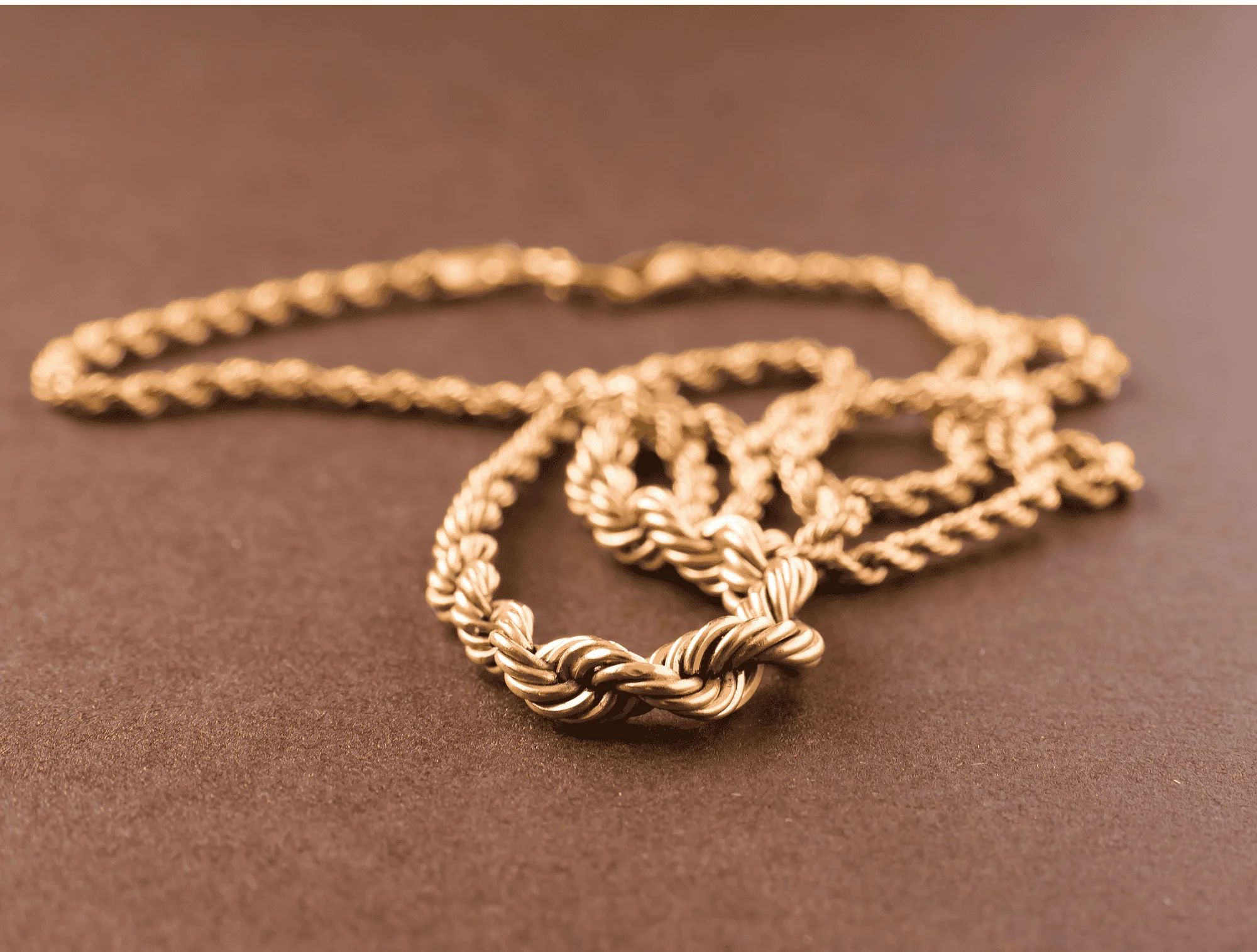 a gold chain is laying on a tabletop