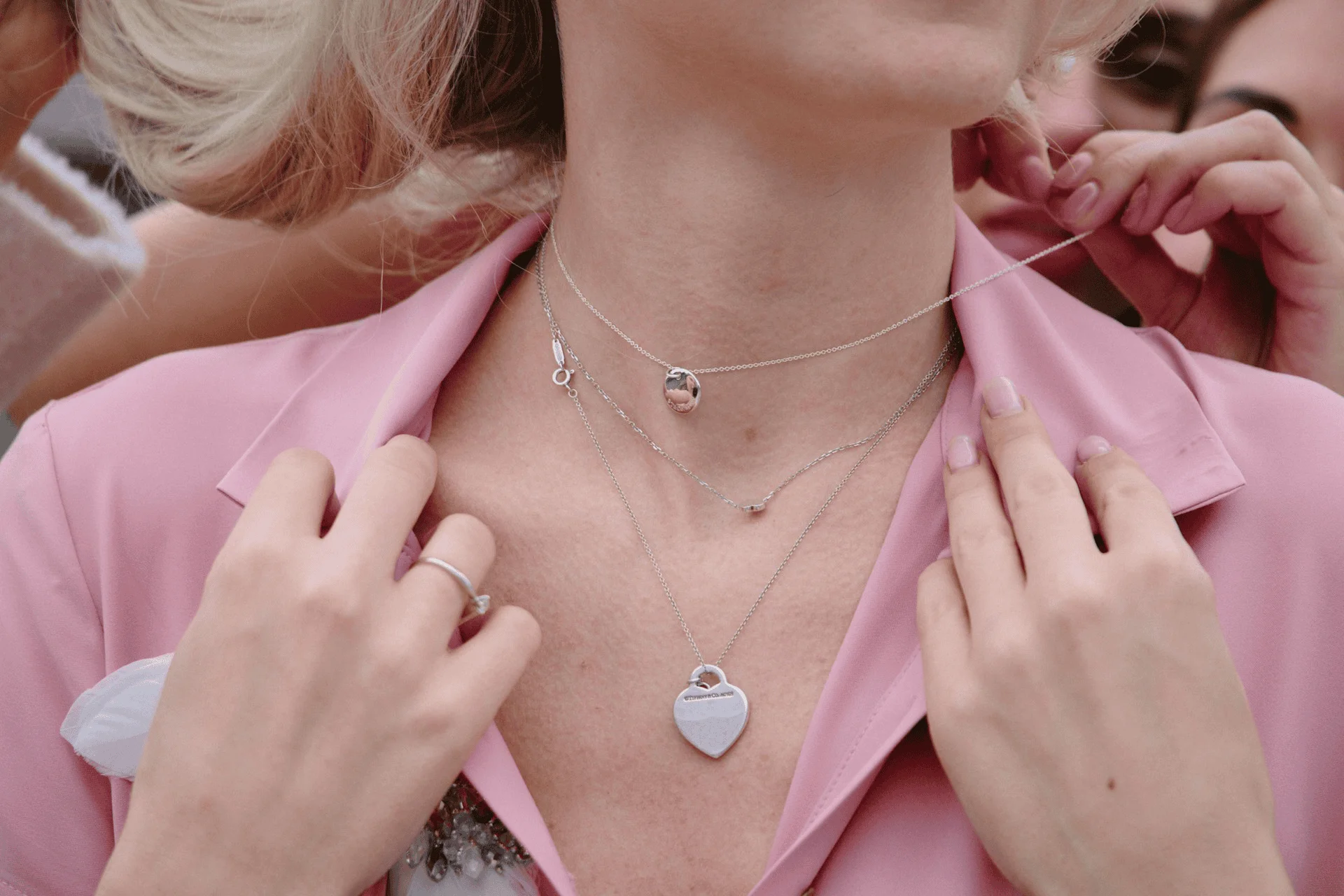 A woman shows off a Tiffany necklace in her stack