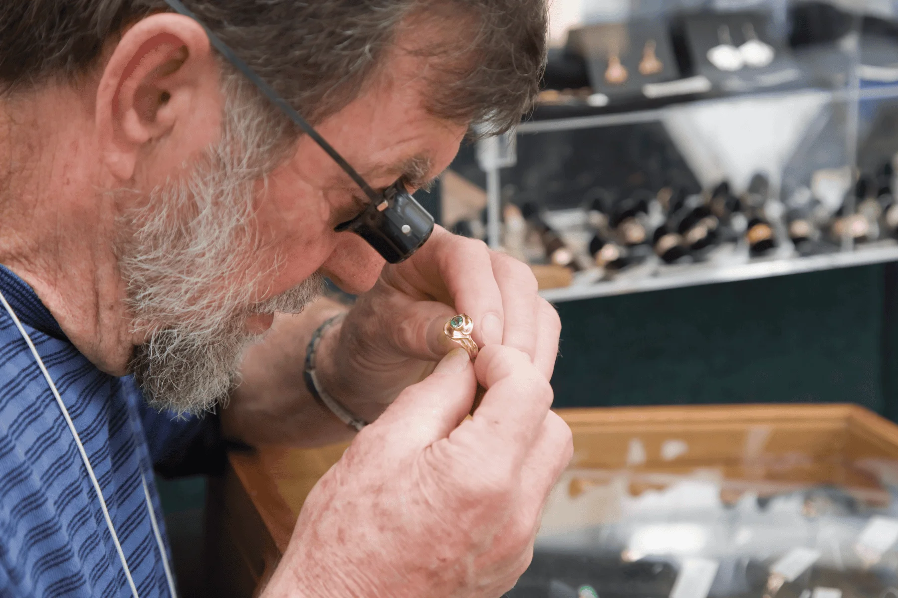 a jeweler examines a gold ring