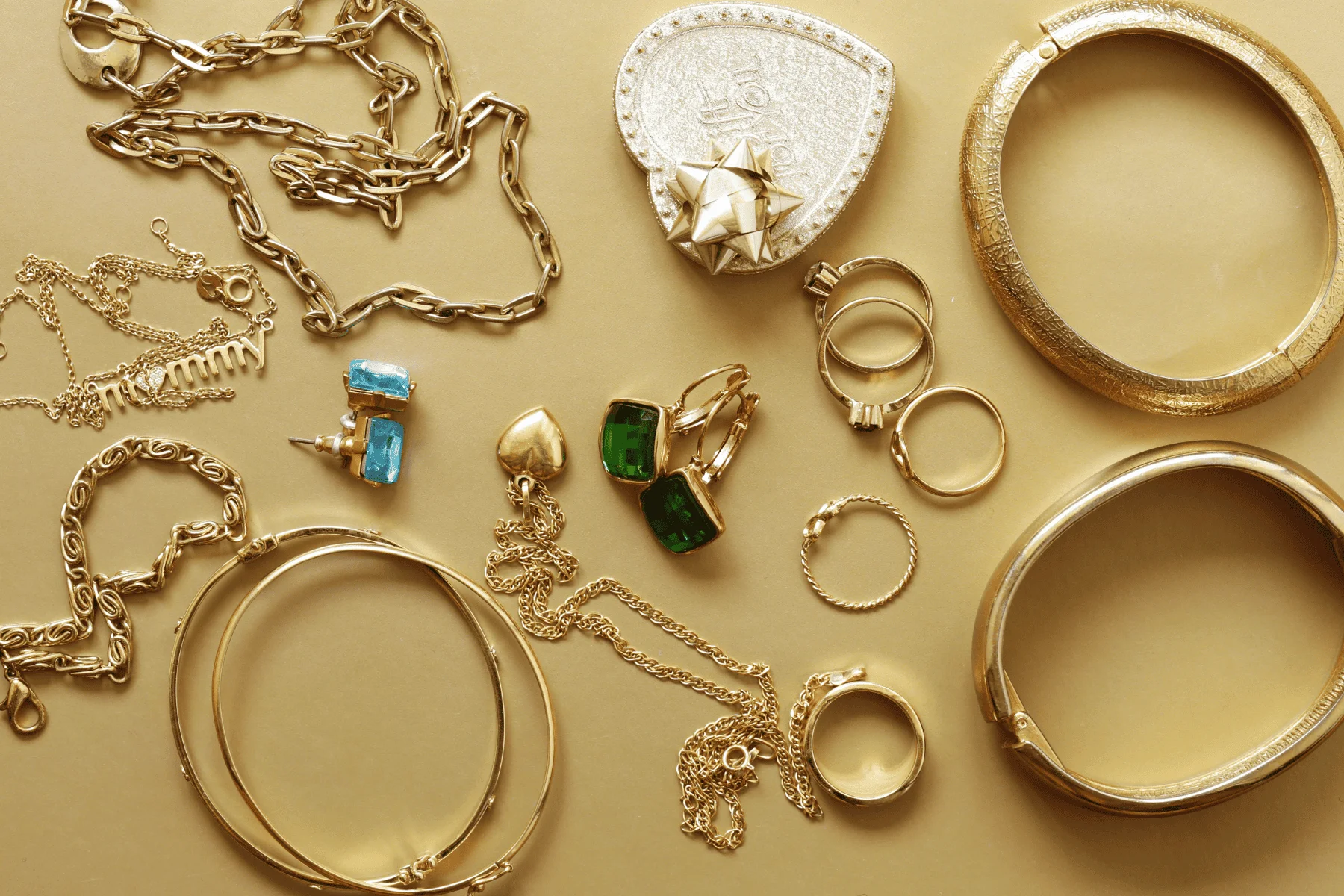various gold jewelry pieces laid out on a table top