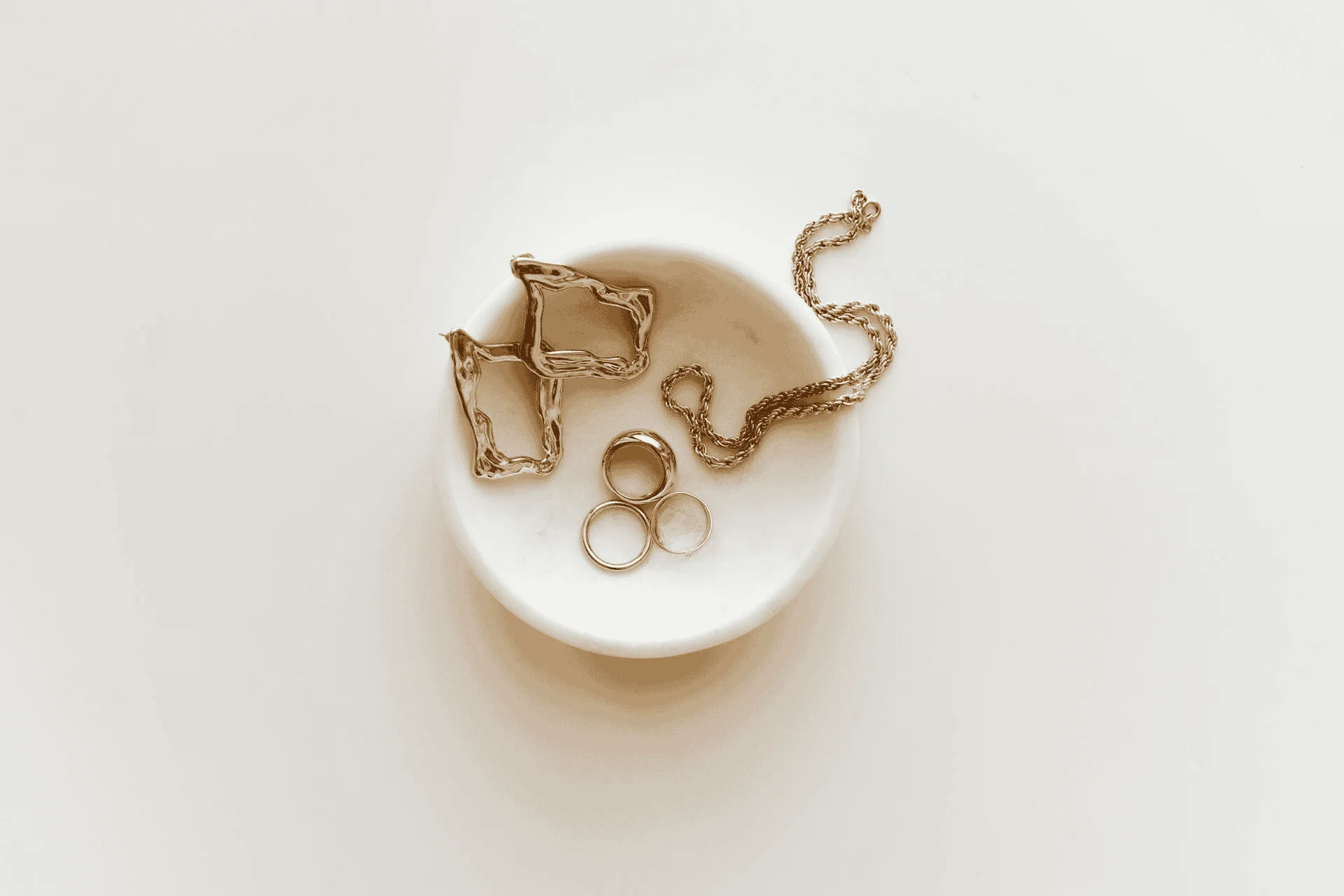 gold jewelry in a white bowl