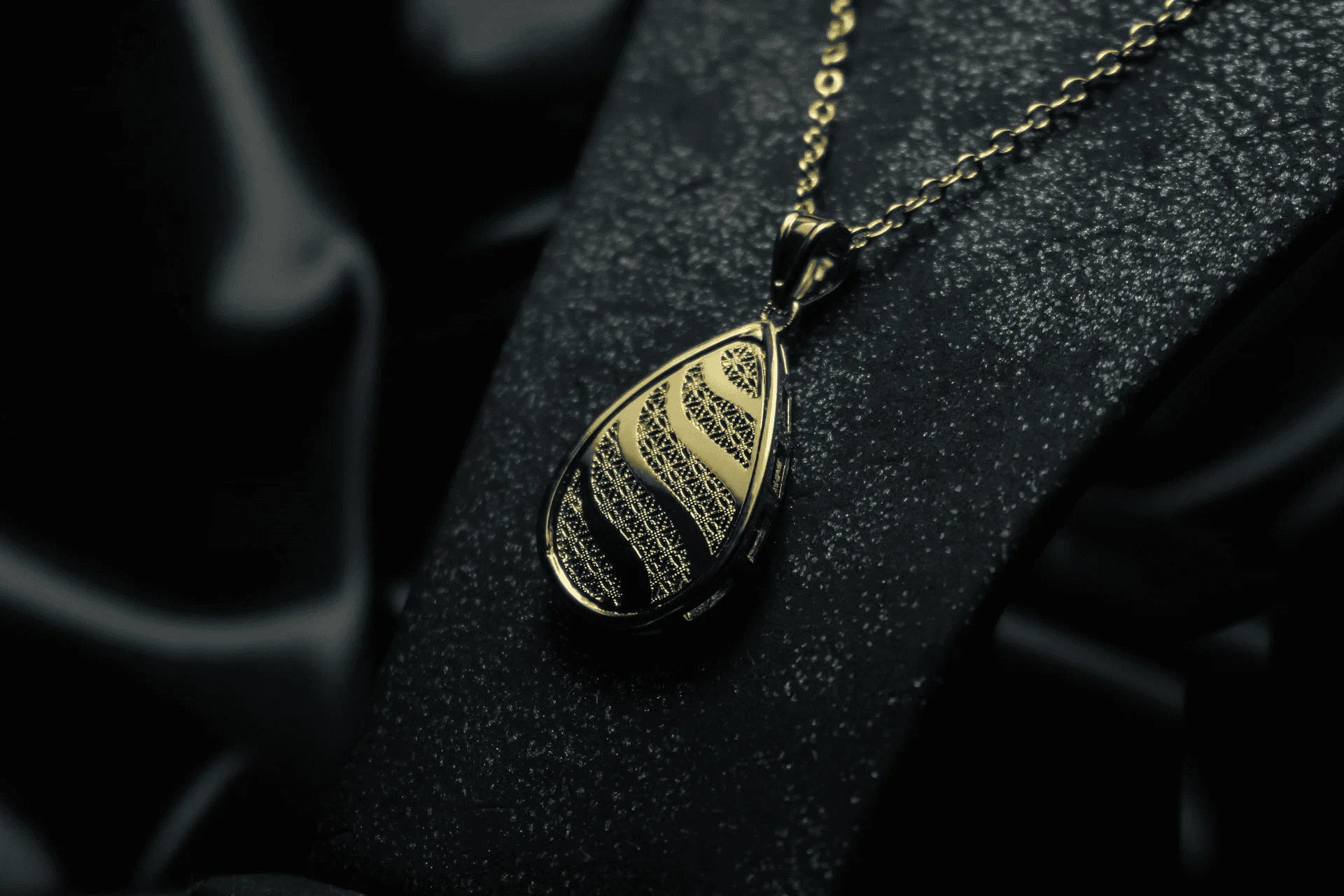 Gold necklace on a black backdrop